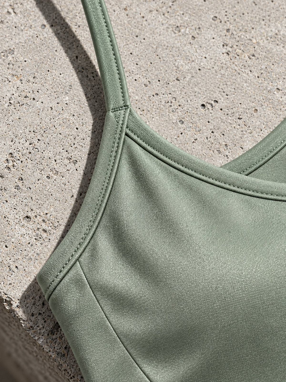 Détail des fines bretelles de la brassière Flow sauge